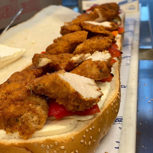 A long deli sandwich filled with crispy chicken cutlets, red peppers, and fresh mozzarella cheese.